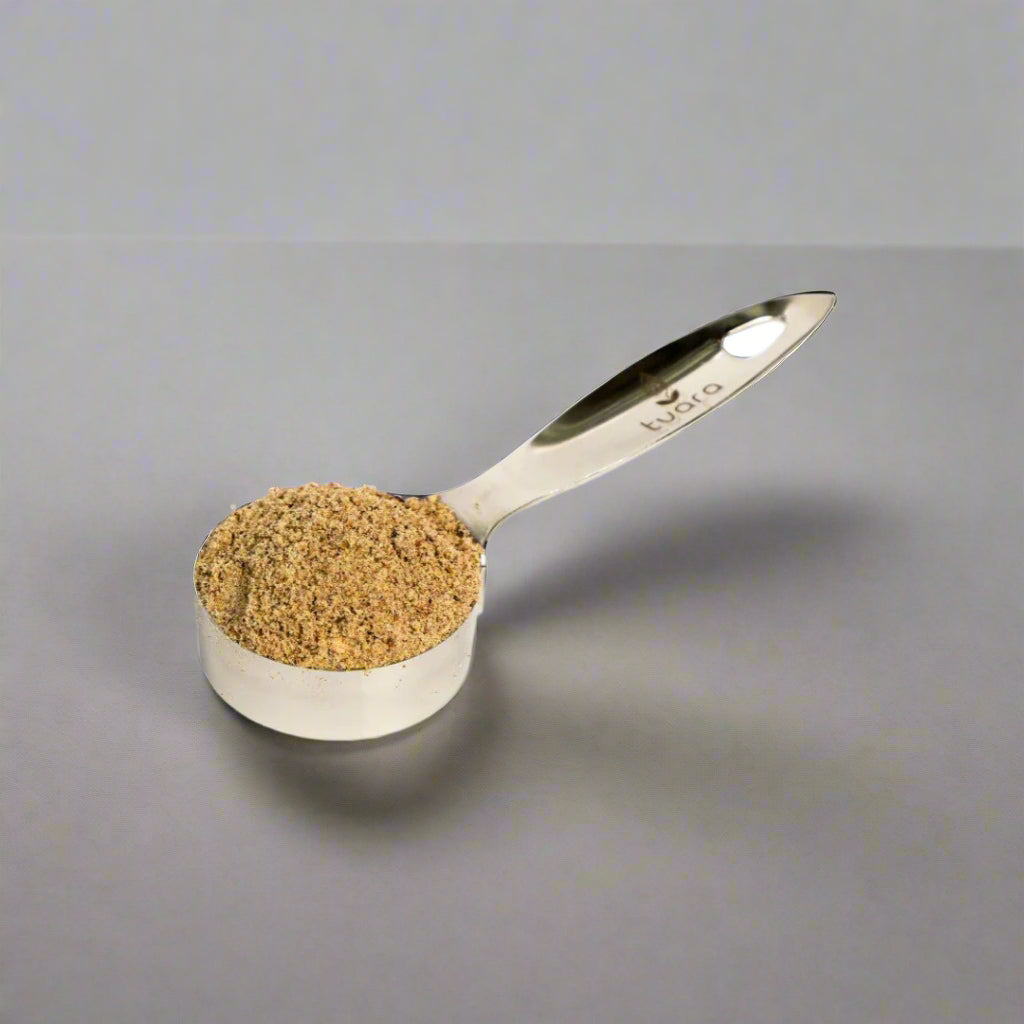 Measuring spoon filled with brown powder on a white background