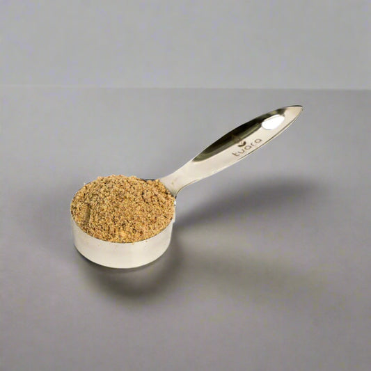 Measuring spoon filled with brown powder on a white background